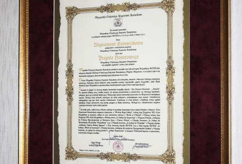 Karneol Nr 01.12 • Akt nadania tytułu Prezesa Honorowego. Ręczne zdobienia. Oprawa w passe partout i profilowaną ramę.